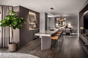 Modern kitchen island with bar stools, dining table, and contemporary decor in an open-plan room.